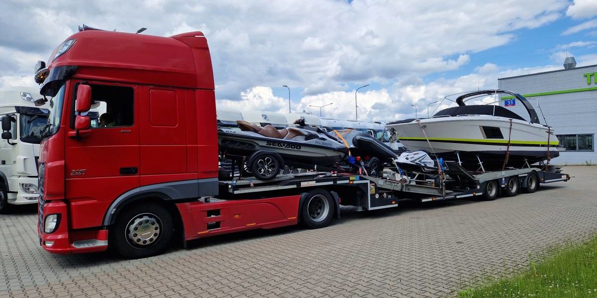 Camion transportant des bateaux et jet-skis sur une remorque, prêt à être livré